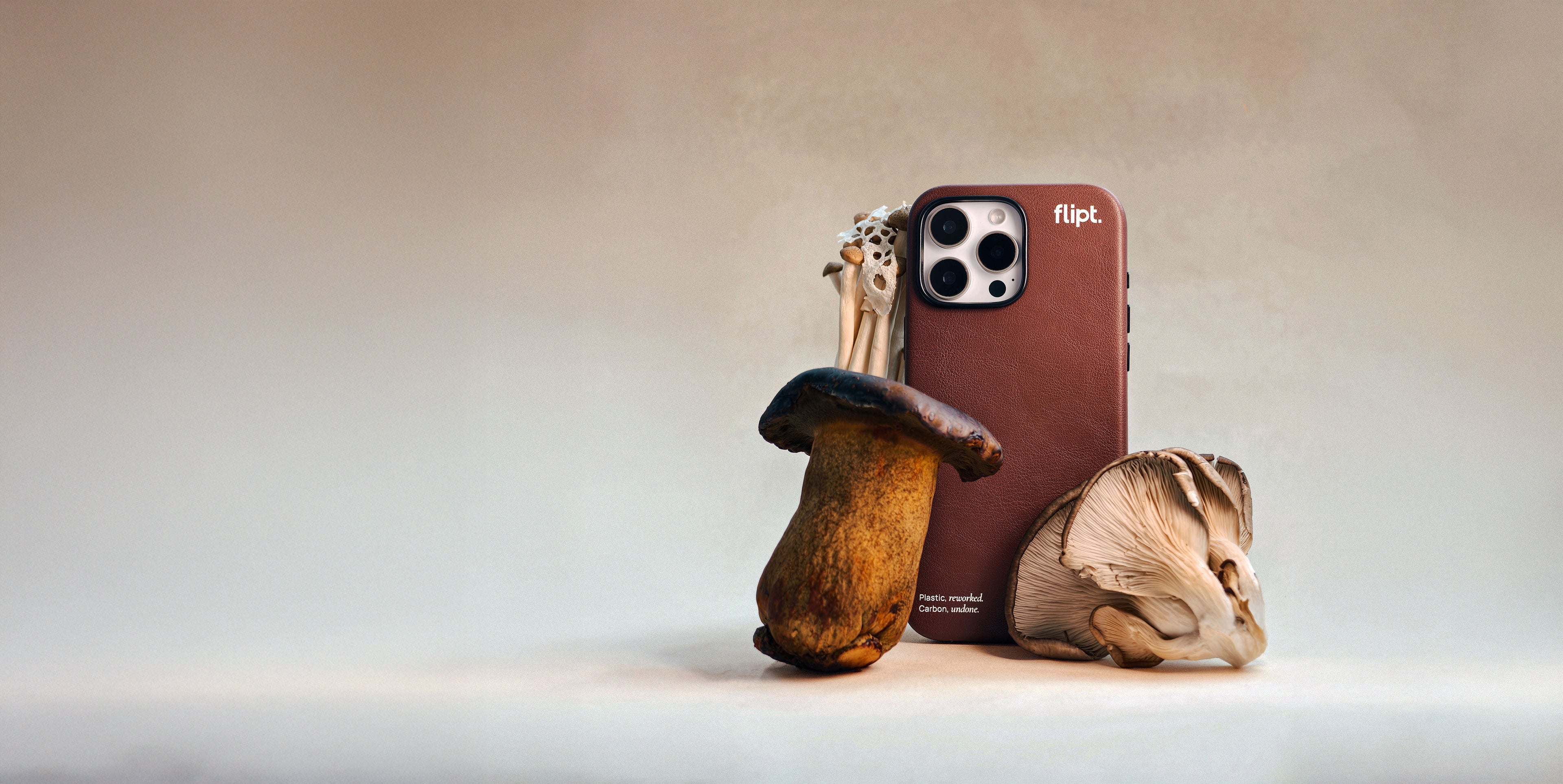 Phone case shaped like a mushroom with a phone and keychain on a neutral background
