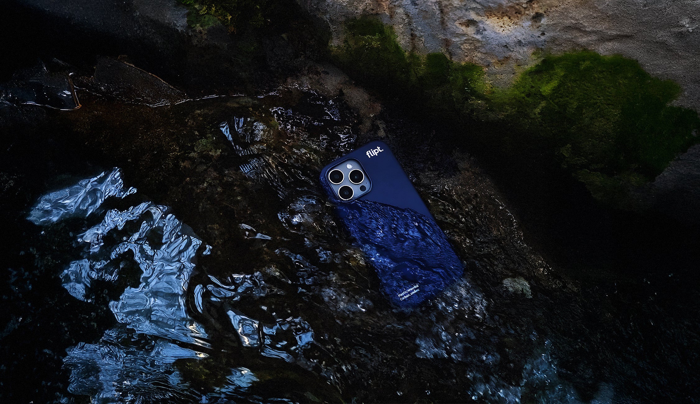 Blue phone case on a rock with water reflection
