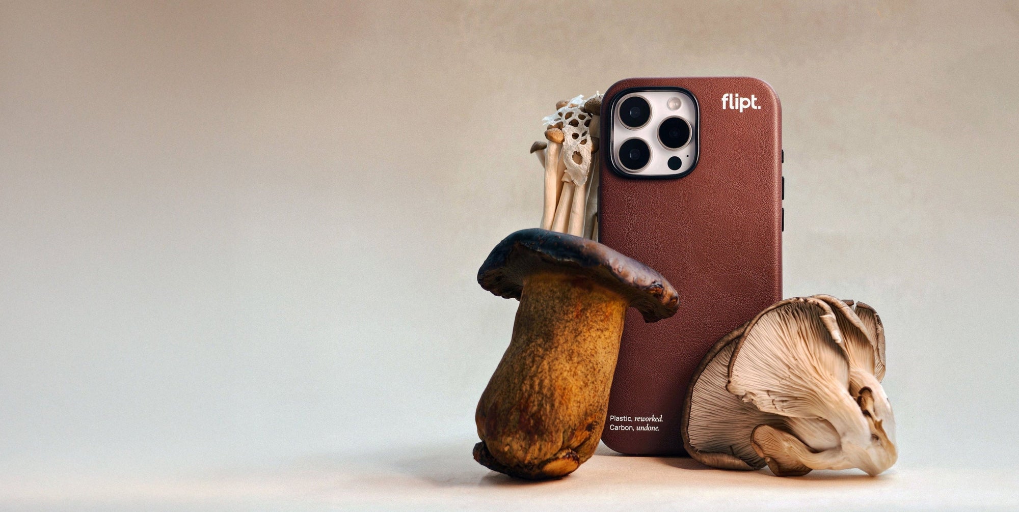 Phone case shaped like a mushroom with a phone and keychain on a neutral background
