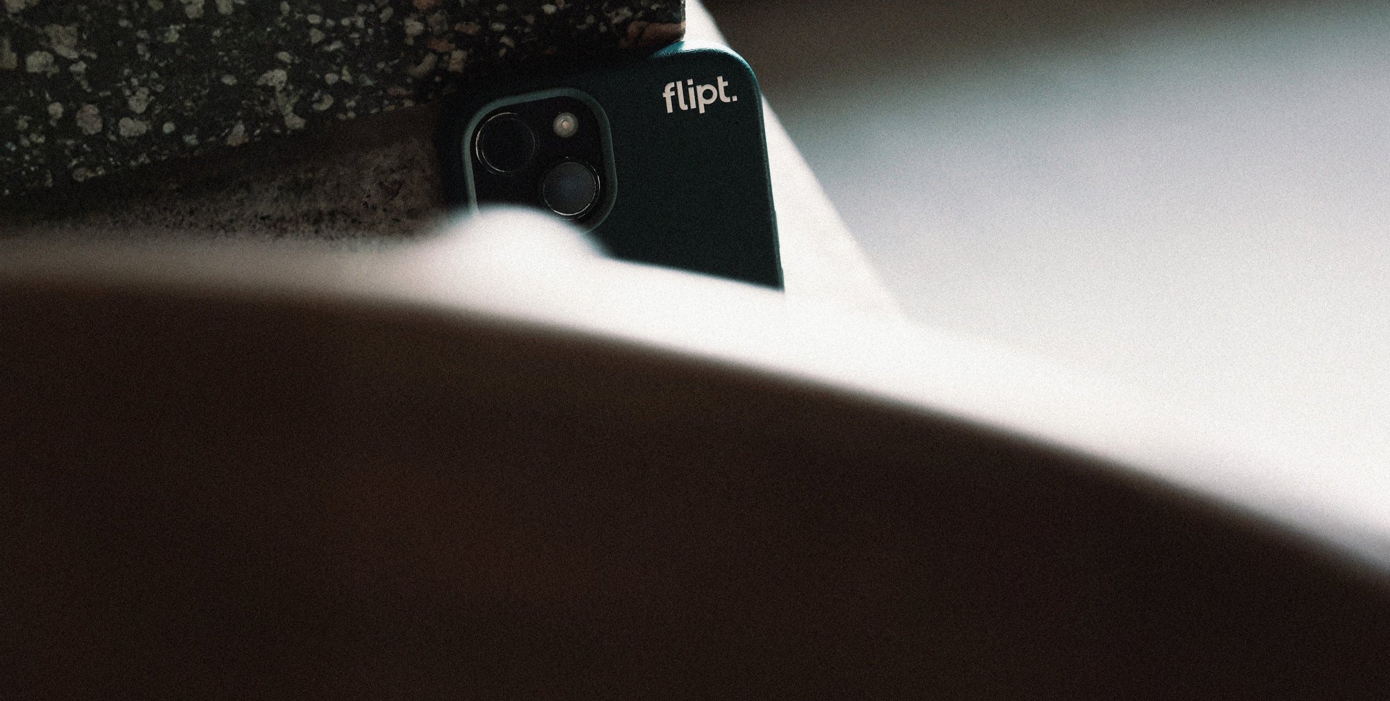 Close-up of a phone case with 'flip' branding on a textured surface.